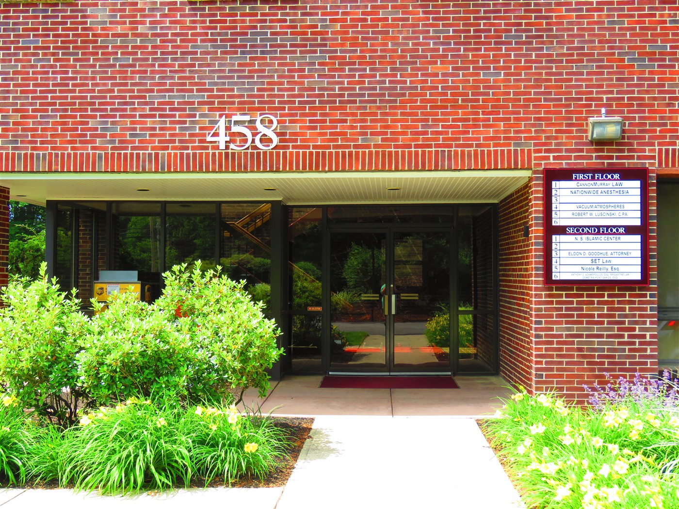 Entrance to 458 Boston Street with the building number above the glass doors.